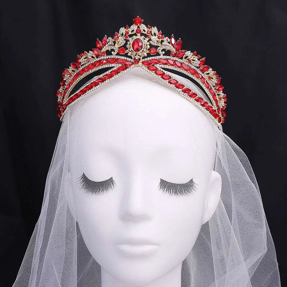 A sparkling red and gold wedding crown headdress with silver floral design and central oval crystal displayed on a mannequin