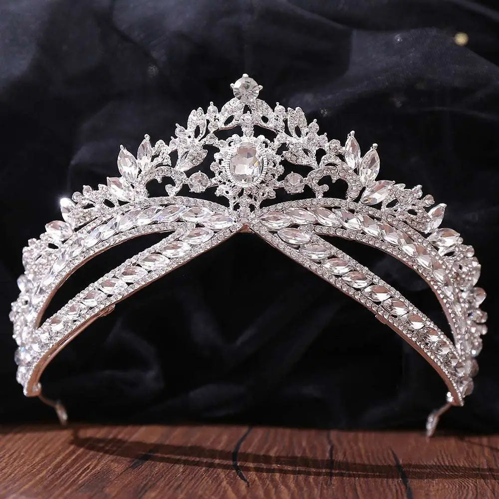A sparkling silver floral wedding crown headdress with intricate leaf designs and an oval crystal centerpiece