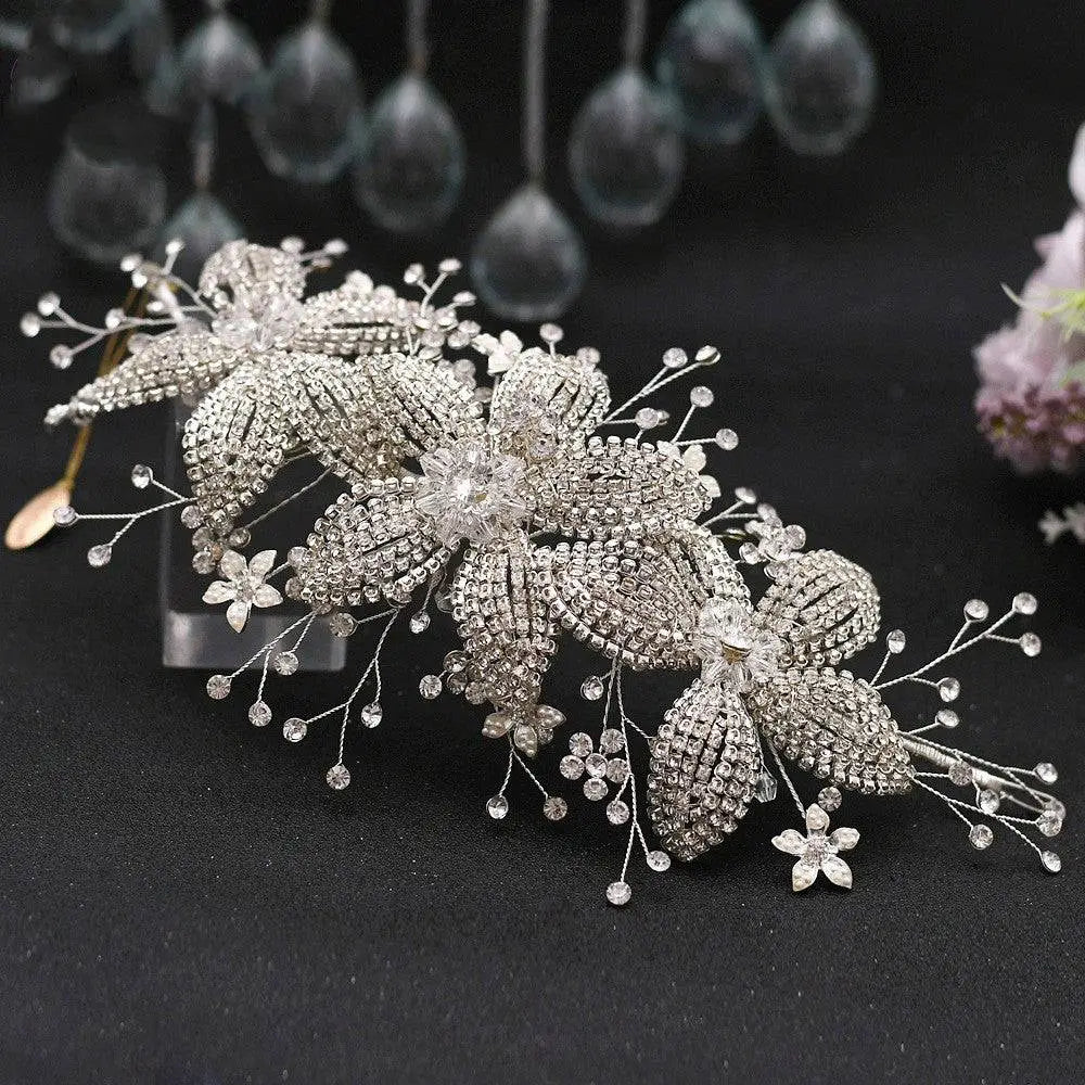Silver flower rhinestone hair accessory with intricate leaf and stem designs and pearl accents for weddings