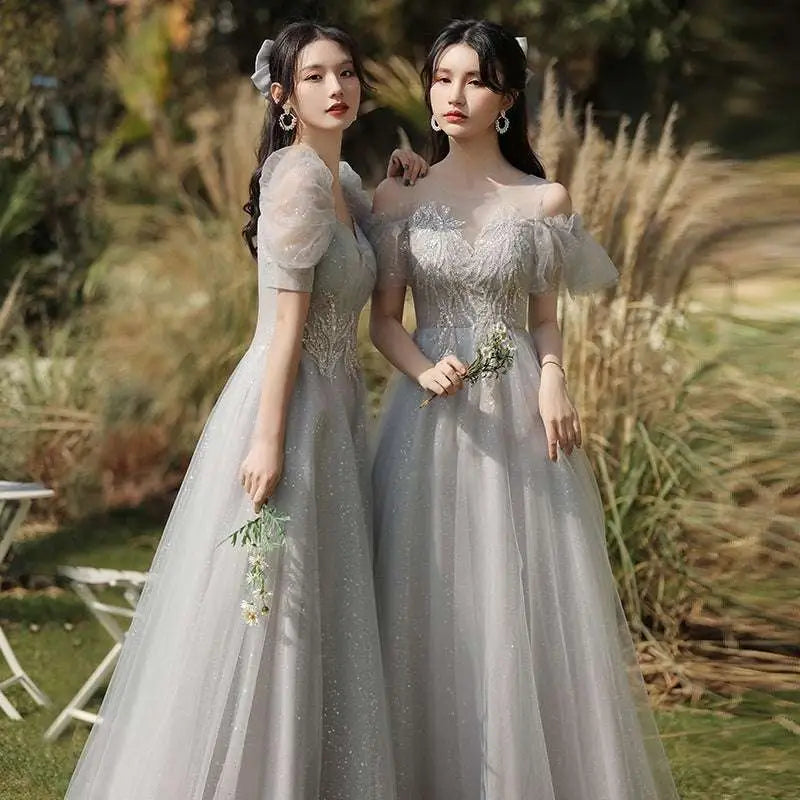 Two women wearing silver gray tulle beaded sisters dress female with off-the-shoulder puffy sleeves and intricate bodices