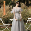 A shimmering silver gray tulle beaded sisters dress female with off-the-shoulder puffy sleeves and round neckline