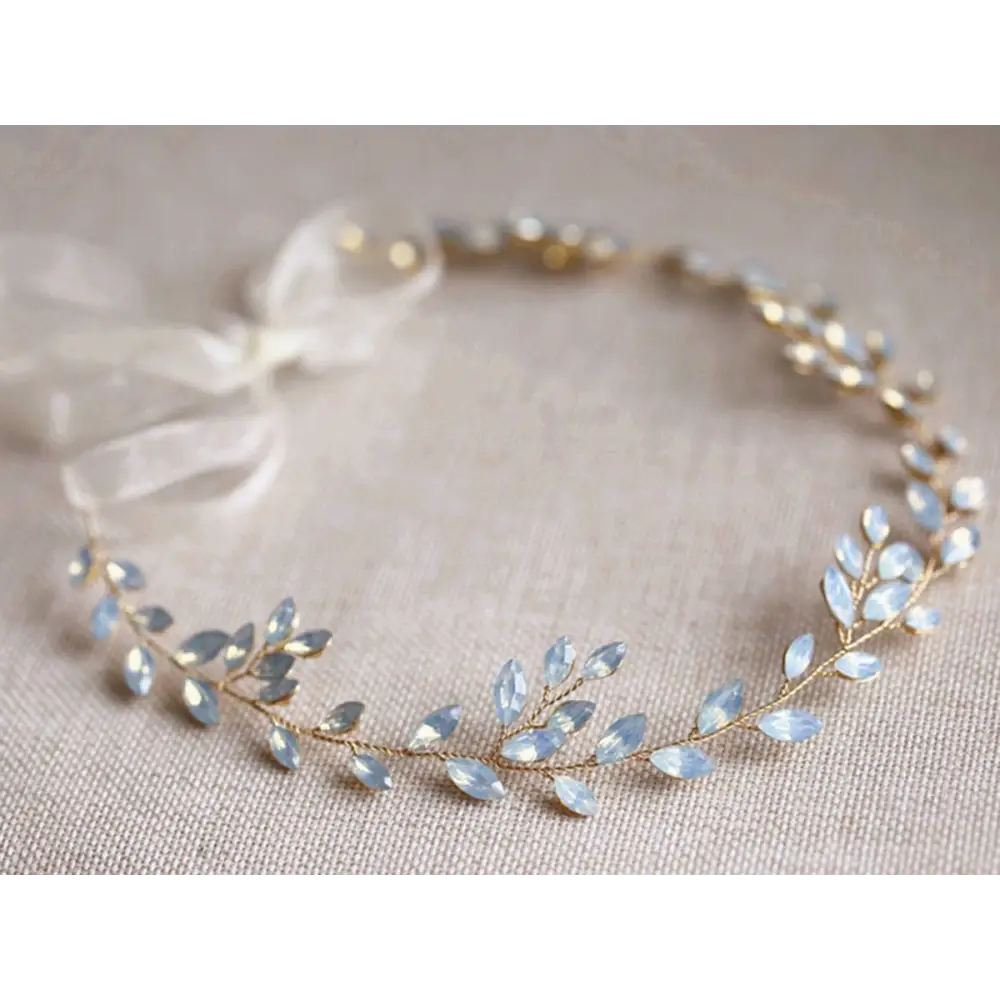 Delicate gold-toned protein rhinestone headdress with light blue faceted crystal leaves and small pearls for hair adornment