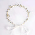 Delicate gold-toned silver leaf protein rhinestone headdress with shimmering silver leaves and white satin bow hair band