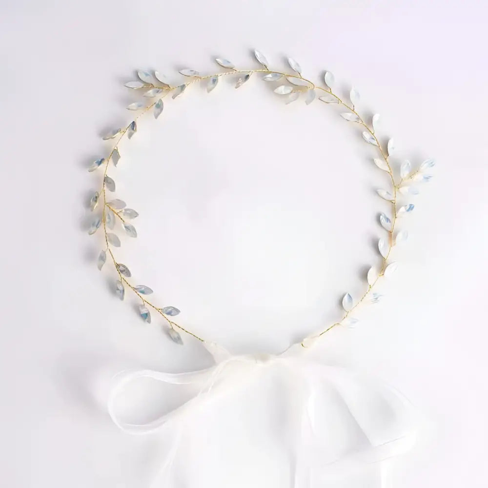 Delicate gold-toned silver leaf protein rhinestone headdress with shimmering silver leaves and white satin bow hair band