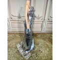 A silver metallic sequined luxury evening dress with a structured silhouette and cascading fringe for stage advanced light use