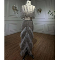 Silver nude feathered two-piece evening gown with sheer embellished bodice and flowing skirt with feather accents
