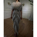Silver nude feathered evening dress featuring a shimmering silver beaded gown with sheer embellished feather accents