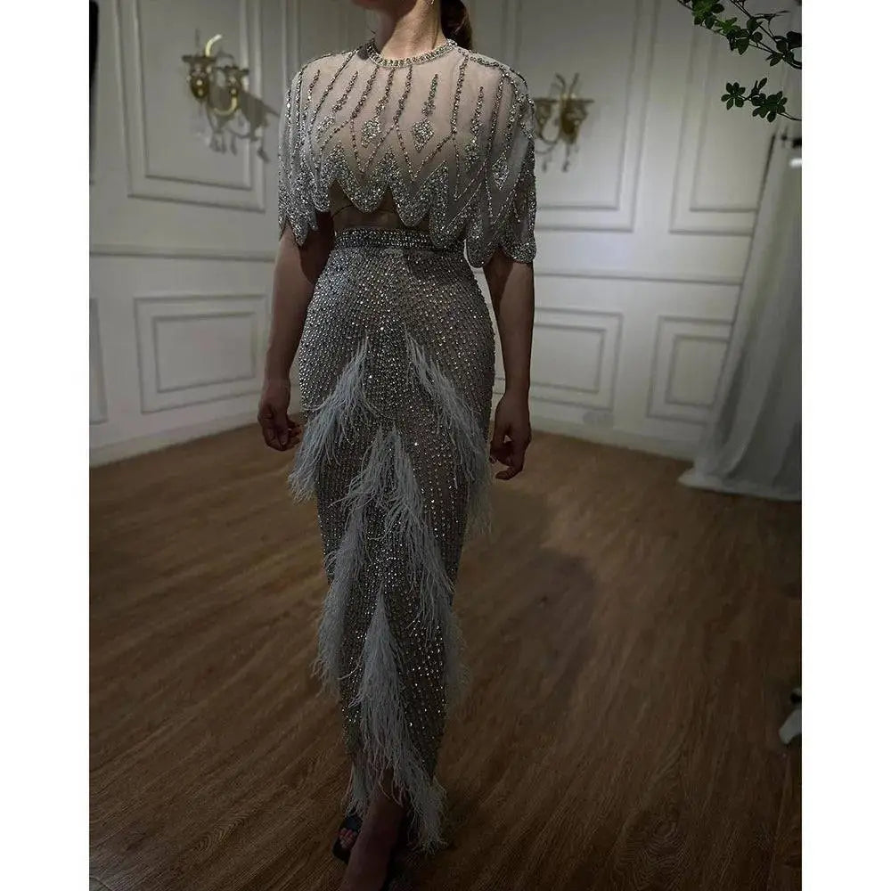 Silver nude feathered evening dress featuring a shimmering silver beaded gown with sheer embellished feather accents