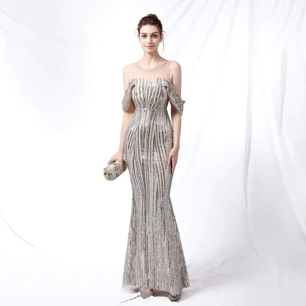 Silver off-the-shoulder sequined mermaid gown with fitted bodice and flowing skirt in shimmering silver fabric