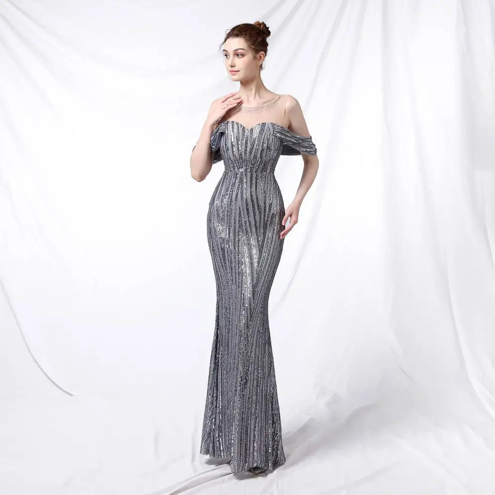 Silver off-the-shoulder sequined mermaid gown with fitted bodice and flowing skirt in shimmering silver fabric