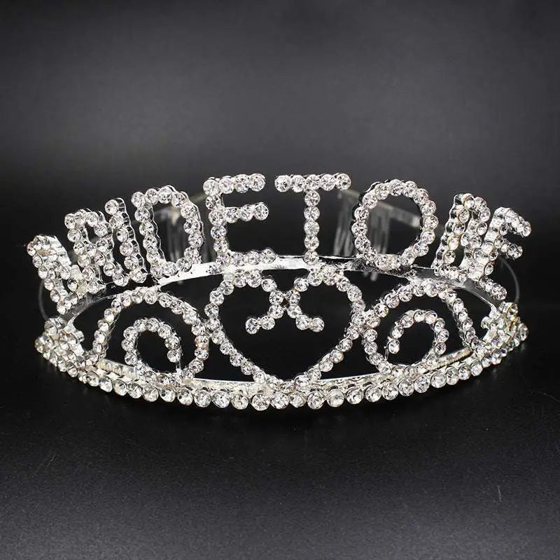 A sparkling silver rhinestone bridal headband featuring the word queen and intricate swirling patterns for luxury women’s fashion