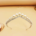 A delicate silver wedding crown alloy adorned with lustrous white pearls and sparkling rhinestones along the band