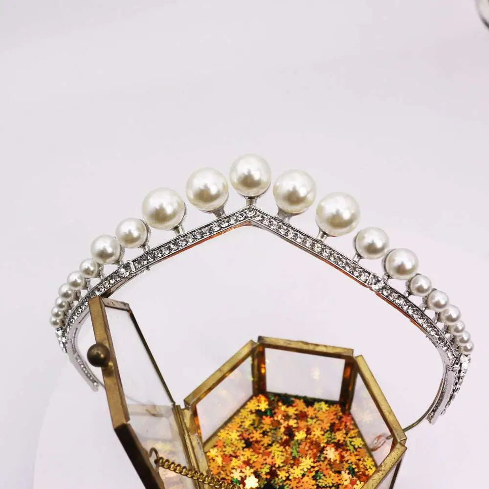Silver wedding crown alloy tiara adorned with lustrous white pearls and sparkling rhinestones over glass box