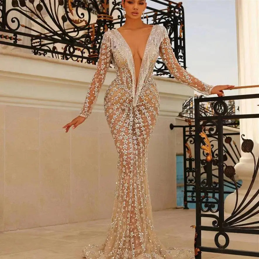 Silver sequined backless tight fishtail gown with long sheer sleeves and a plunging v-neckline in shimmering fabric
