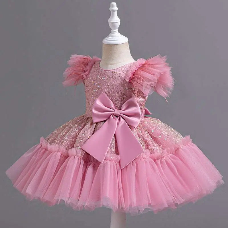 Pink sequined toddler dress with tulle puff sleeves and satin bow in a silver sequined wedding dress tulle style