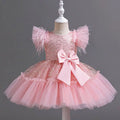 A delicate pink sequined wedding dress tulle skirt with feathered sleeves and a large satin bow at the waist
