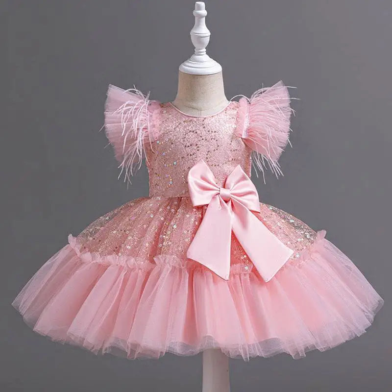 A delicate pink sequined wedding dress tulle skirt with feathered sleeves and a large satin bow at the waist