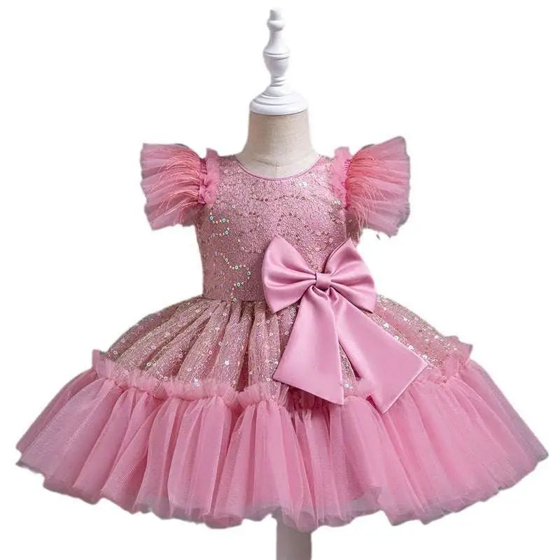 Pink sequined toddler dress with ruffled tulle skirt and matching satin bow for a sequined wedding dress tulle look