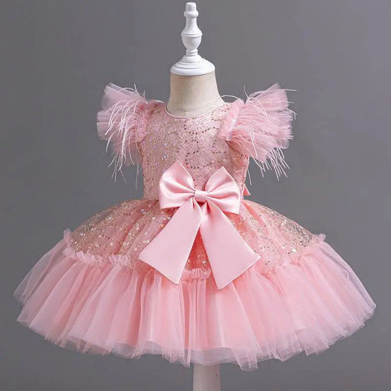 Pink sequined toddler dress with feathered sleeves and layered tulle skirt accented by satin bow for wedding dress tulle
