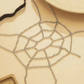 Silver spiderweb geometric body chain with interlocking links forming a delicate silver thigh garter design