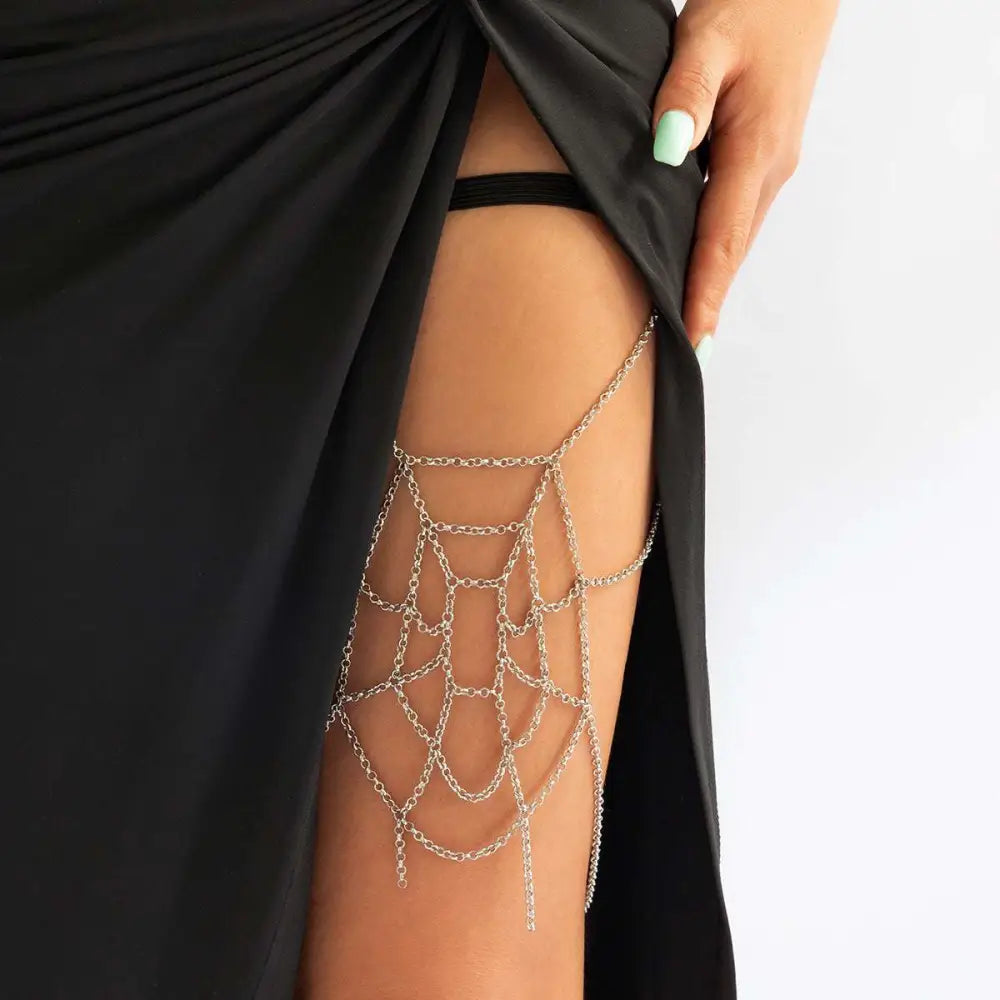 Silver spiderweb geometric thigh garter featuring delicate silver chain links and dangling tassels as a body chain accessory