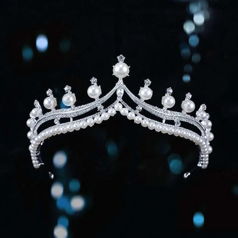 A silver starburst bridal crown baroque tiara with white pearls and embedded crystals in a regal design