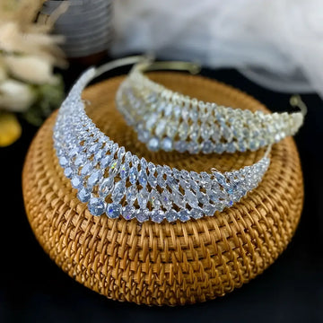 A silver super flash zircon crown tiara featuring a woven metal design with clear faceted crystals sparkling brightly