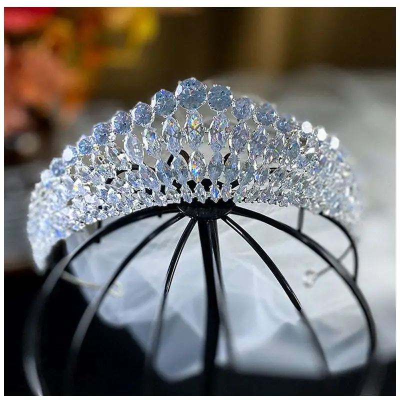 A silver super flash zircon crown tiara with sparkling clear and light blue crystals in an elegant arched design