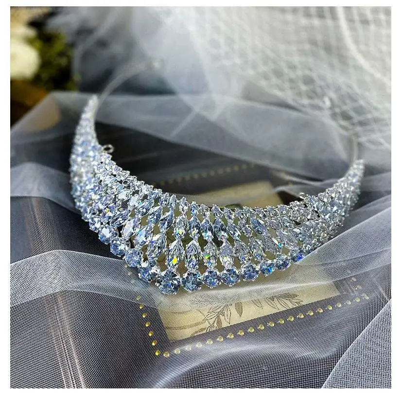 A silver super flash zircon crown tiara featuring cascading rows of clear and light blue crystals in a sparkling design