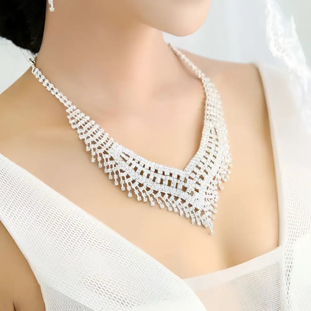 A silver tiara with intricate lace detailing and american rhinestone claw chain features sparkling rhinestones