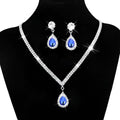Silver v-shaped crystal bridal jewelry set featuring a sparkling silver necklace with blue teardrop gemstone and matching earrings