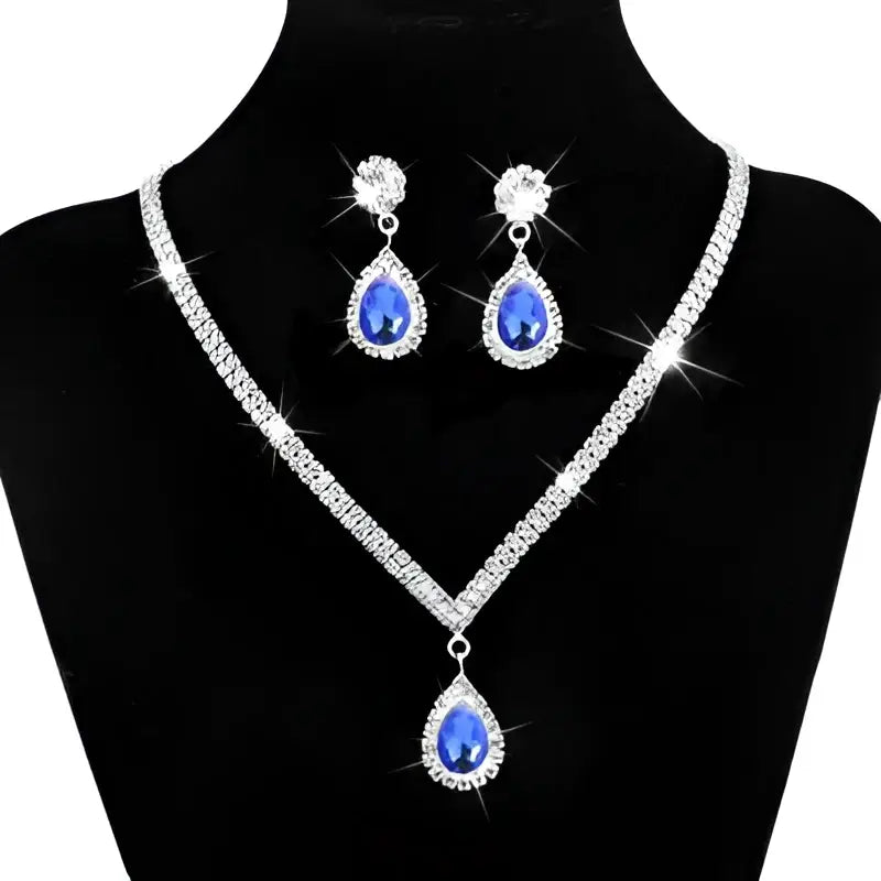 Silver v-shaped crystal bridal jewelry set featuring a sparkling silver necklace with blue teardrop gemstone and matching earrings