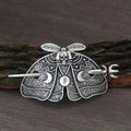 Silver-toned female viking barrettes featuring a silver moth hairpin with skull head and crescent moon motifs on wings