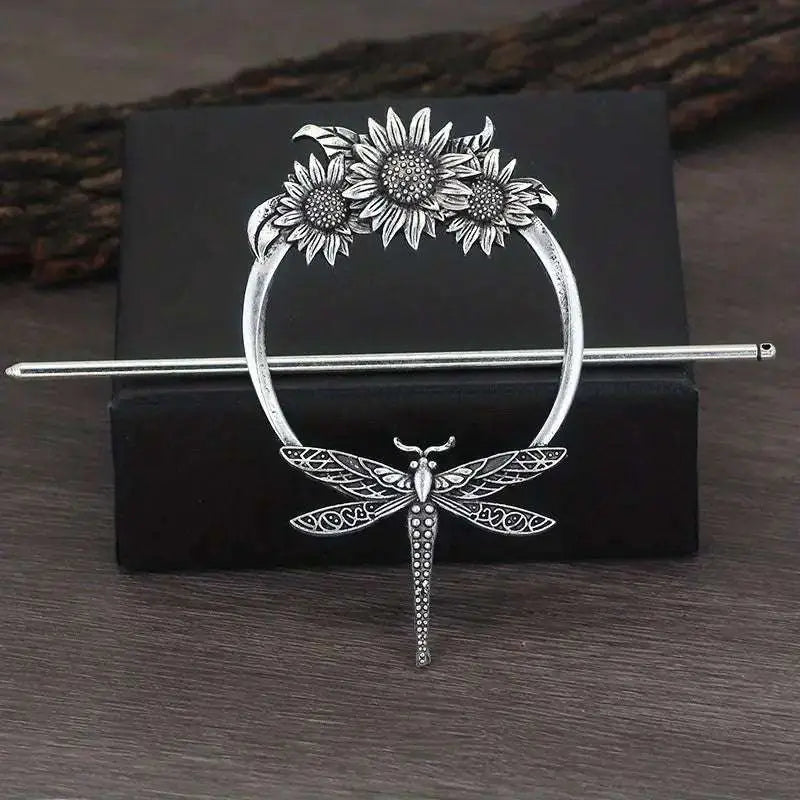 Silver-toned female viking barrettes with ornate circular design featuring sunflowers and a detailed dragonfly pendant