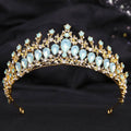 A golden crystal bridal crown featuring light blue teardrop crystals and white leafy opal design with clear rhinestones