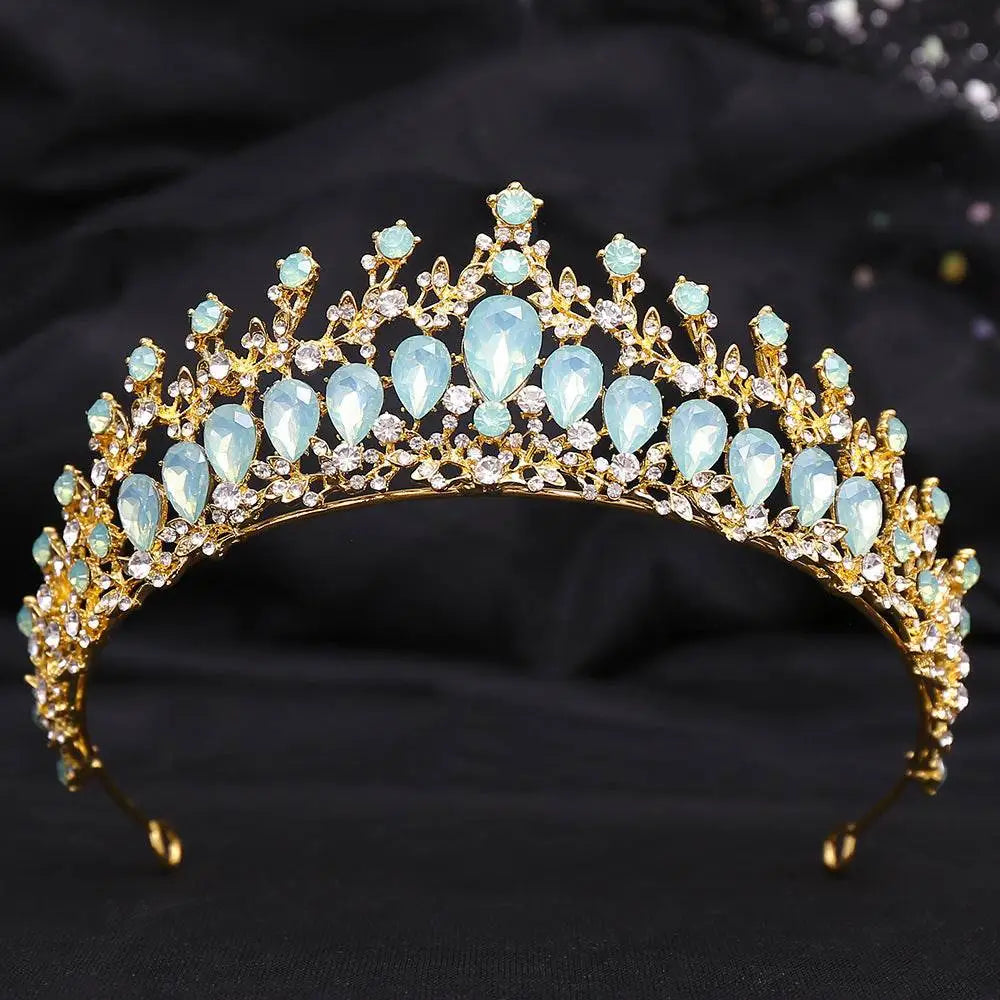 A golden crystal bridal crown featuring light blue teardrop crystals and white leafy opal design with clear rhinestones