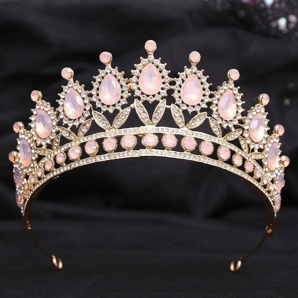 A gold-toned crystal bridal crown featuring pink rose quartz teardrop stones and a white leafy opal motif design
