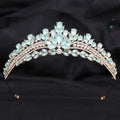 A gold-toned crystal bridal crown featuring light blue teardrop crystals and white leafy opal in an elegant design