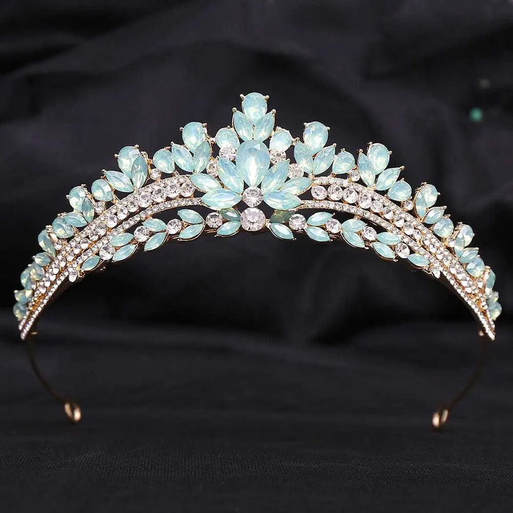 A gold-toned crystal bridal crown featuring light blue teardrop crystals and white leafy opal in an elegant design