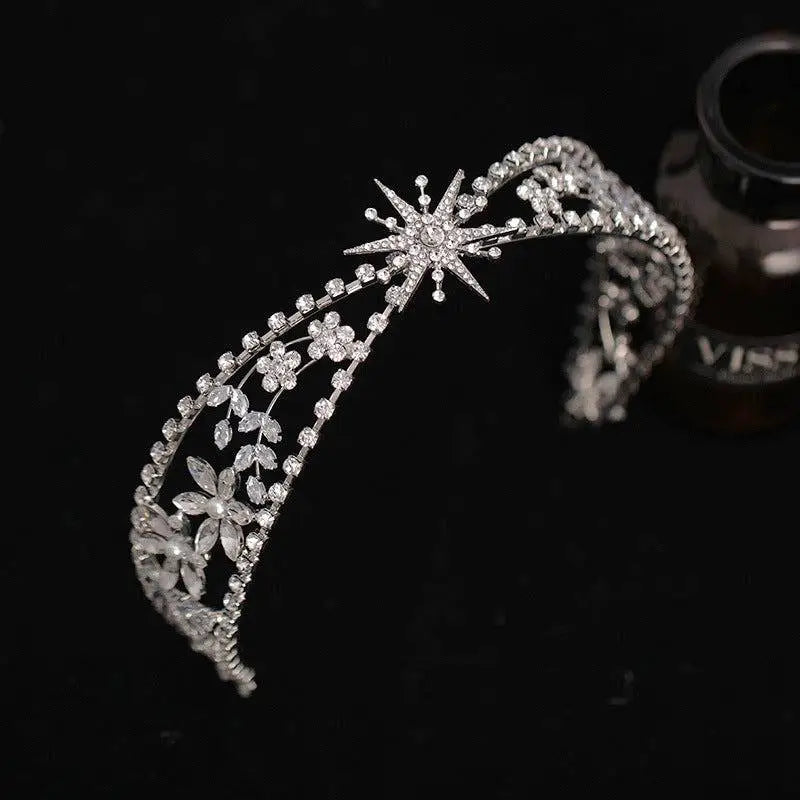 A silver zircon bridal crown headdress with a delicate metal framework featuring floral and starburst crystals