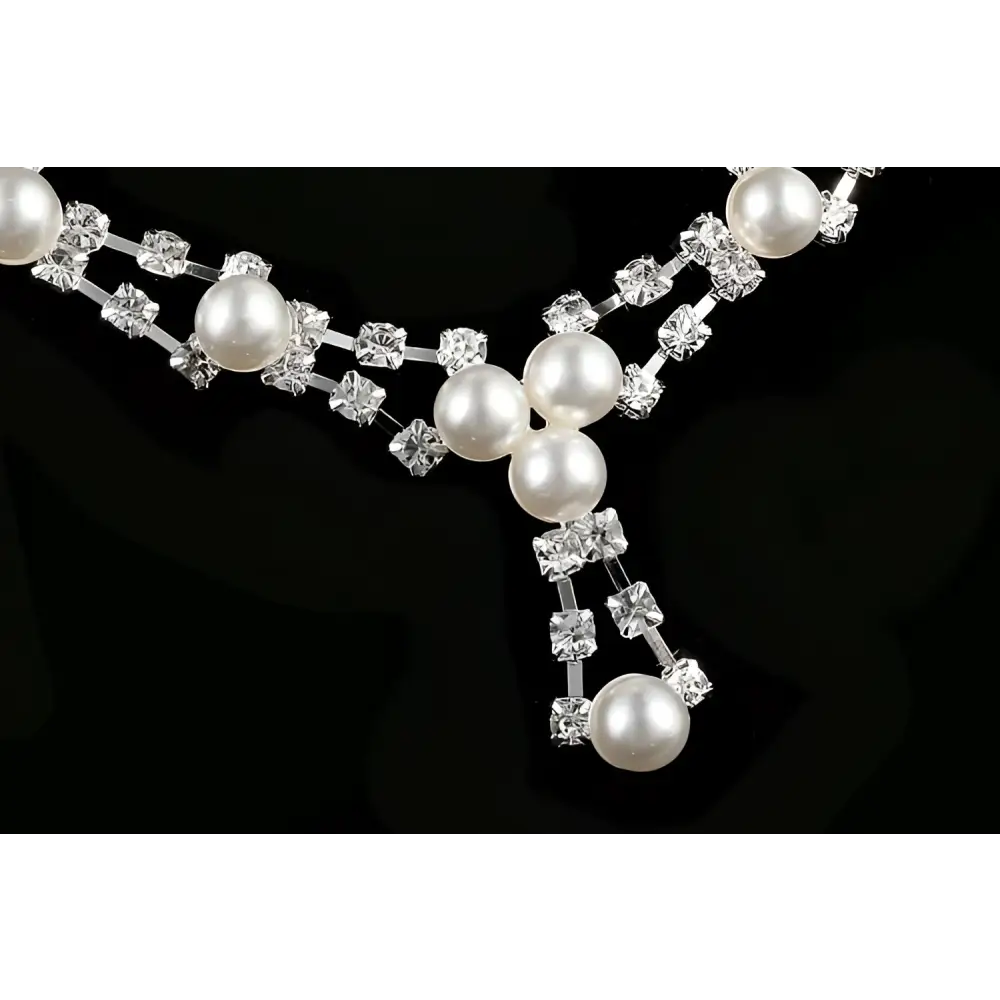 A delicate silver simple bride jewelry pearl necklace with cascading white pearls and clear wedding rhinestones