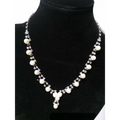 A delicate silver simple bride jewelry necklace with white pearls and rhinestones displayed on black velvet bust