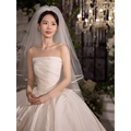 A simple elegant french style white satin wedding dress with a strapless bodice and voluminous skirt