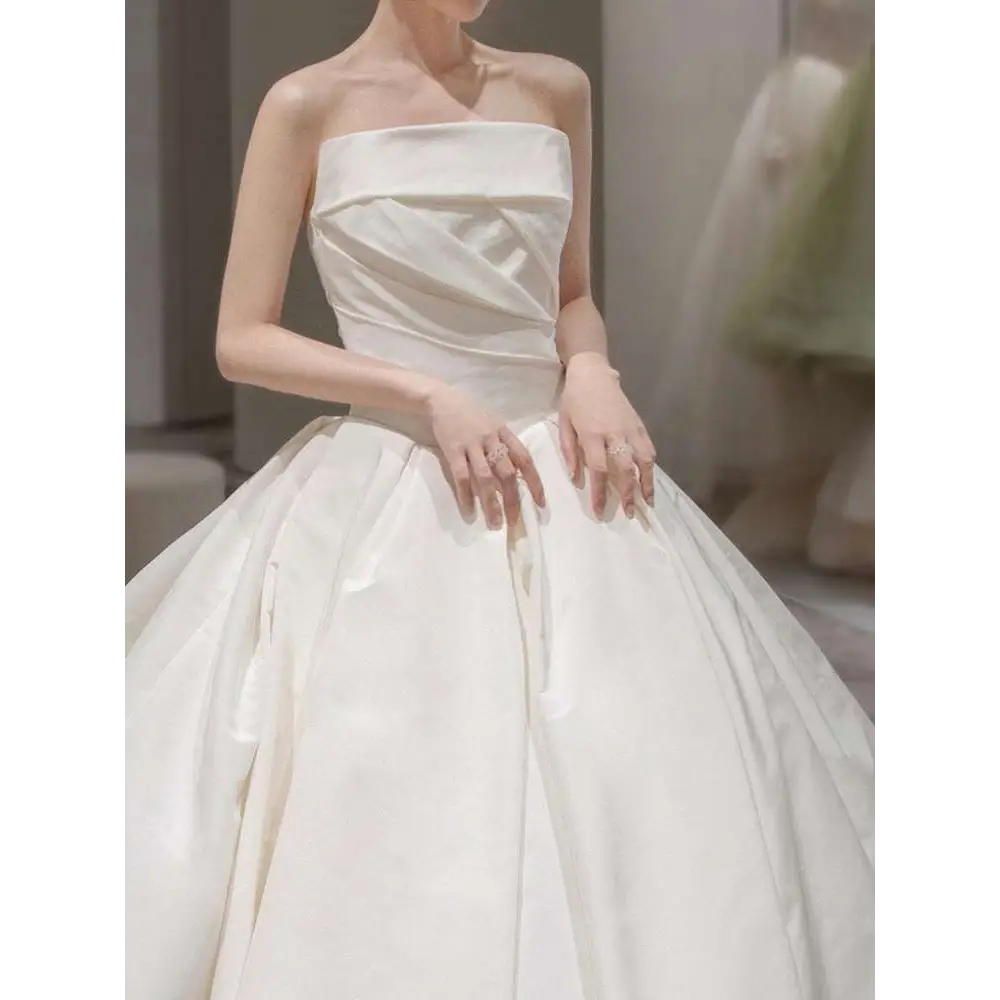 Simple elegant French style strapless white satin wedding dress with structured bodice and voluminous skirt