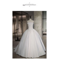 A simple elegant French style white satin wedding dress with fitted bodice and voluminous skirt on a mannequin