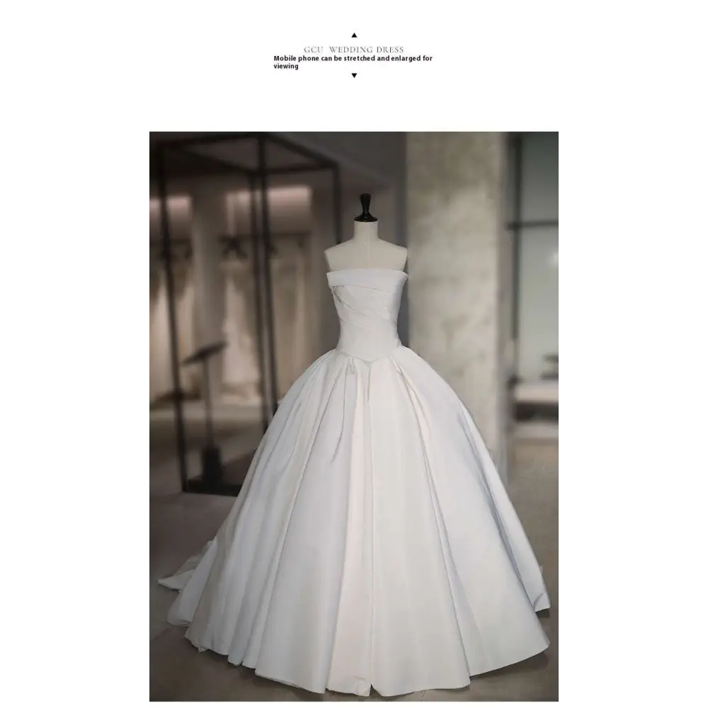A simple elegant French style white satin wedding dress with fitted bodice and voluminous skirt on a mannequin