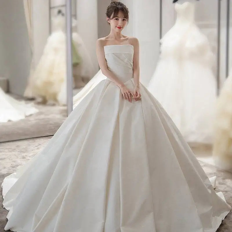 Simple elegant french style white satin wedding dress with strapless fitted bodice and voluminous skirt