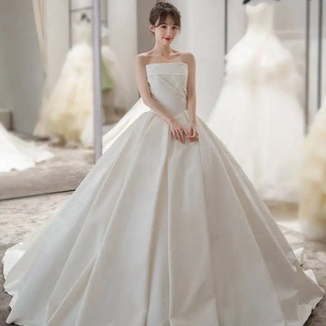 Simple elegant french style white satin wedding dress with strapless fitted bodice and voluminous skirt