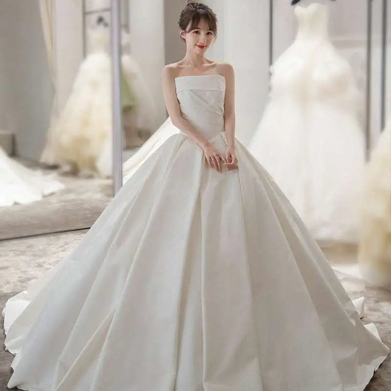 Simple elegant french style strapless white satin wedding dress with fitted bodice and voluminous skirt