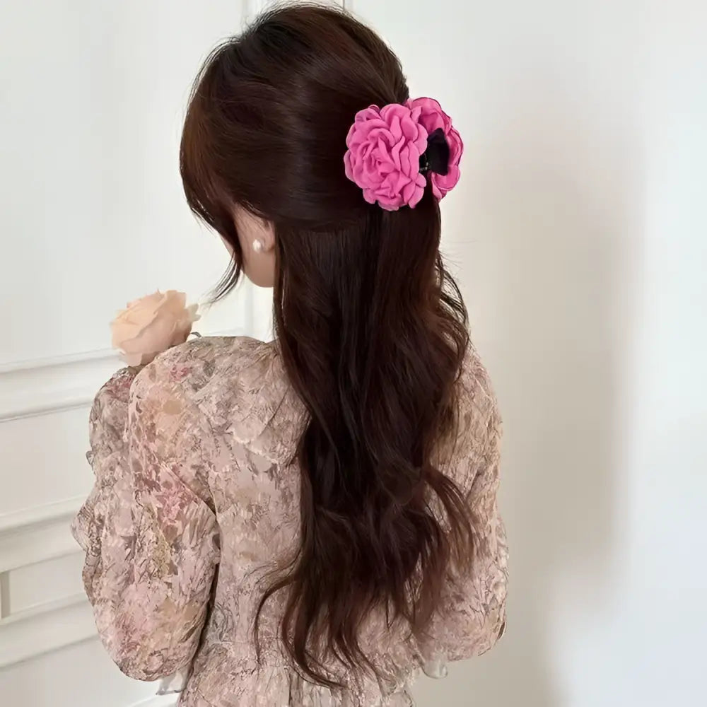 Simple graceful barrettes featuring a vibrant pink fabric rose hair clip with layered ruffled petals on a black base